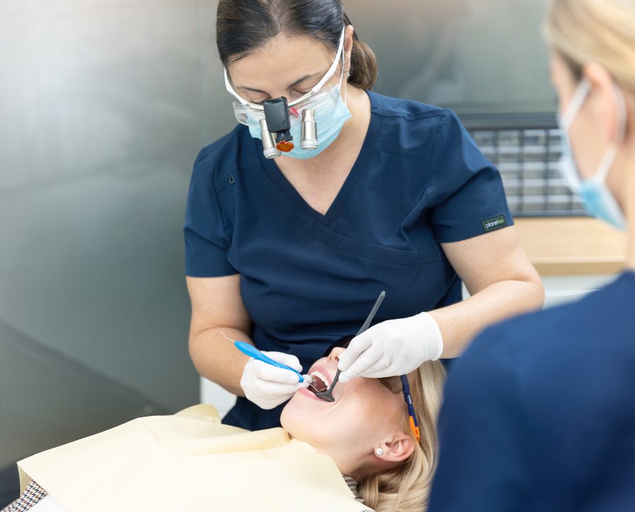 Dr. Kristina Kiisa working with a patient, wearing loupes